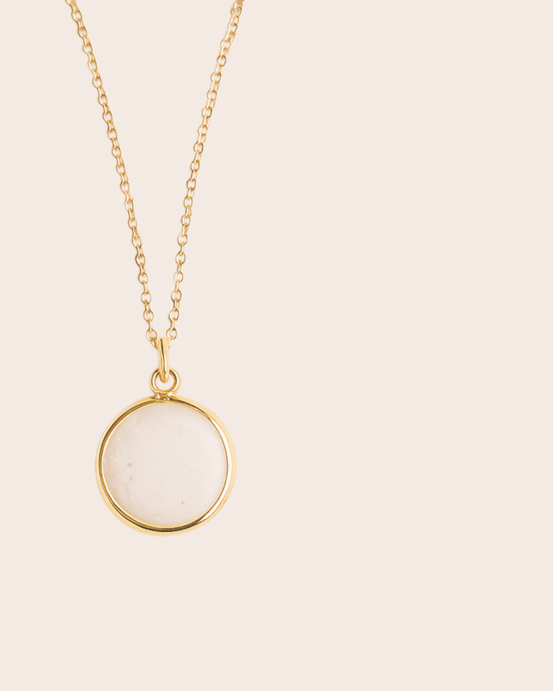 Necklace with a round pendant on a beige background